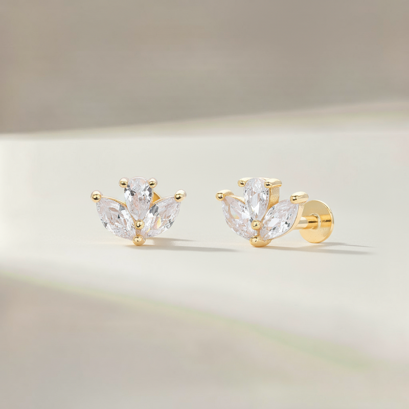 Gold earrings with clear gemstones on a soft background